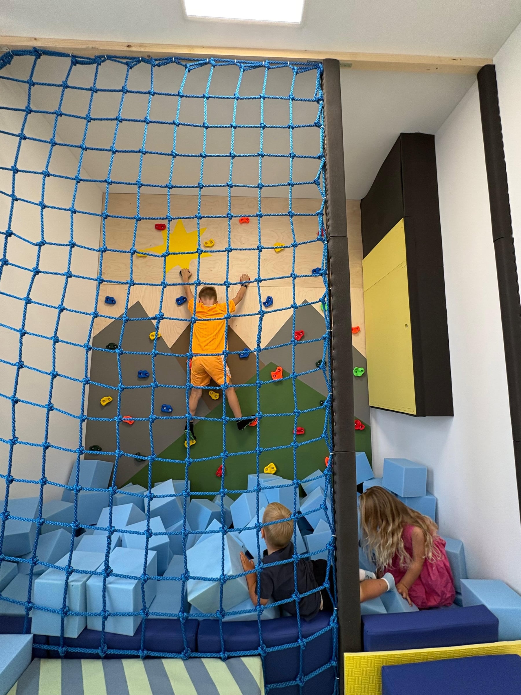 Djeca se igraju na penjalici i u bazenu sa spužvastim kockama